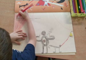 Chłopiec rysujący swoją wizualizację świata wokół głoski b